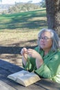 older white-haired woman with a rosary beads in her hand and a bible praying Royalty Free Stock Photo