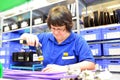 older woman assembles electronic components in a hi tech factory