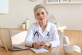 Older woman doctor therapist wearing headset video call talking to web camera consulting virtual patient online Royalty Free Stock Photo