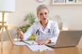 Older woman doctor therapist wearing headset video call talking to web camera consulting virtual patient online Royalty Free Stock Photo