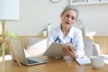 Older woman doctor therapist wearing headset video call talking to web camera consulting virtual patient online Royalty Free Stock Photo