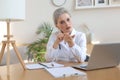 Older woman doctor therapist wearing headset video call talking to web camera consulting virtual patient online Royalty Free Stock Photo