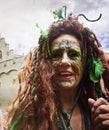 Older woman dressed as witch with green makeup at public fantasy festival