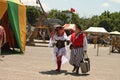 Older woman dressed in very costume and older man dressed as a pirate look at each other fondly as they walk through Renassia