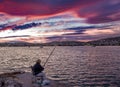 Older woman fishing and enjoy the view of Porto Rafti town under