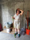 Older woman gardener smiling and holding a pitchfork