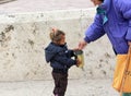 Older woman give money to cute beggar girl downtown of Skopje,capital of Macedonia