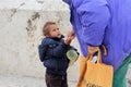 Older woman gives money to cute beggar girl downtown of Skopje,capital of Macedonia