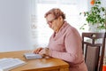 A woman in her senior years reading a book while sitting comfortably in her favorite chair at home Royalty Free Stock Photo