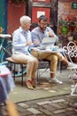 An older woman and her young male friend enjoying a coffee while watching a laptop content in a bar. Leisure, bar, outdoor, Royalty Free Stock Photo