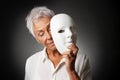 Older woman hiding sad face behind mask Royalty Free Stock Photo