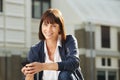 Older woman holding smart phone smiling and sitting outside Royalty Free Stock Photo