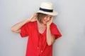 Older woman laughing with hat against gray wall Royalty Free Stock Photo