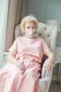 Older woman in medicine mask at home, 70 years old