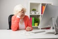 Older woman at the office having headache