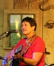 Older woman plays guitar and sings