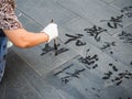 Older woman practicing water calligraphy