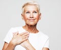 older woman presses her hands to her chest and feels happy, good news Royalty Free Stock Photo