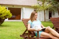 Older woman relaxing in home garden with book