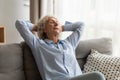 Older woman relaxing at home, sleeping on comfortable couch Royalty Free Stock Photo