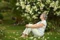 Older woman sitting with flowers Royalty Free Stock Photo