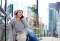 Older woman sitting outside in the city talking on mobile phone Royalty Free Stock Photo