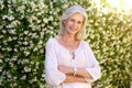 Older woman smiling and standing outside in spring