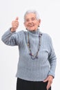 Older woman with thumbs up and smile on white background Royalty Free Stock Photo