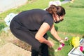 Older woman visiting a loved one at the cemetery paying respects with fresh yellow flowers. Female grieving at graveyard