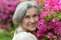 Older woman on walk with pink flowers