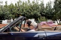 An older woman and a young woman driving a convertible