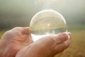 Older womans hand holding a shiny glass sphere Royalty Free Stock Photo