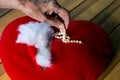 Older womans hand taking jewelry from a ripped stuffed heart