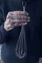 Older womans hands holding an old whisk Royalty Free Stock Photo