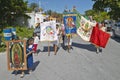 Older women and children marching through streets of Puerto Morelos carrying Mexican flag and Virgen de Guadalupe, Yucatan