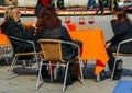 Older women terracing with aperol spritz cocktail in street cafe watching people walking by