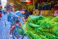 Olderly porter on the bicycle loads heaps of greenery in Pak Khlong Talat Flower Market in Bangkok, Thailand