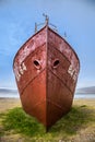 Oldest steel ship in Iceland abandoned rusty ashore in the grass