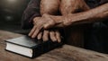 Oldmans hands together in prayer to God along with the bible In the Christian concept and religion, woman pray in the Bible Royalty Free Stock Photo