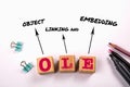 OLE Object Linking and Embedding. Wooden blocks on a white office table