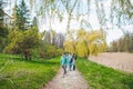 OLESKO, UKRAINE - April 20, 2019: young group of people with kids walking by nature park