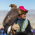 OLGIY, MONGOLIA - SEP 30, 2017: Kazakh Golden Eagle Hunter at traditional clothing, with a golden eagle on his arm