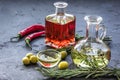 Olive and chili oil with ingredients on kitchen table background