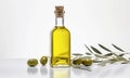Olive fresh extra virgin oil in a glass bottle and green olives with leaves on white background.
