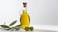 Olive fresh extra virgin oil in a glass bottle and green olives with leaves on white background.