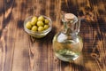 Olive oil in a bottle and fruits of olives in a bowl. Olive oil bottle and olives on wooden background with copy space Royalty Free Stock Photo