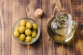 Olive oil in a bottle and fruits of olives in a bowl. Top view. Olive oil bottle and olives on wooden table Royalty Free Stock Photo