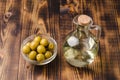 Olive oil in a bottle and fruits of olives in a bowl. Olive oil bottle and olives on wooden table Royalty Free Stock Photo