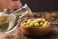Olive oil in a bottle and fruits of olives in a bowl. Olive oil bottle and olives on wooden table Royalty Free Stock Photo