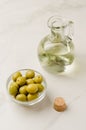Olive oil bottle and olives on white stone table. Selective focus. Olive oil in a bottle and fruits of olives in a bowl Royalty Free Stock Photo
